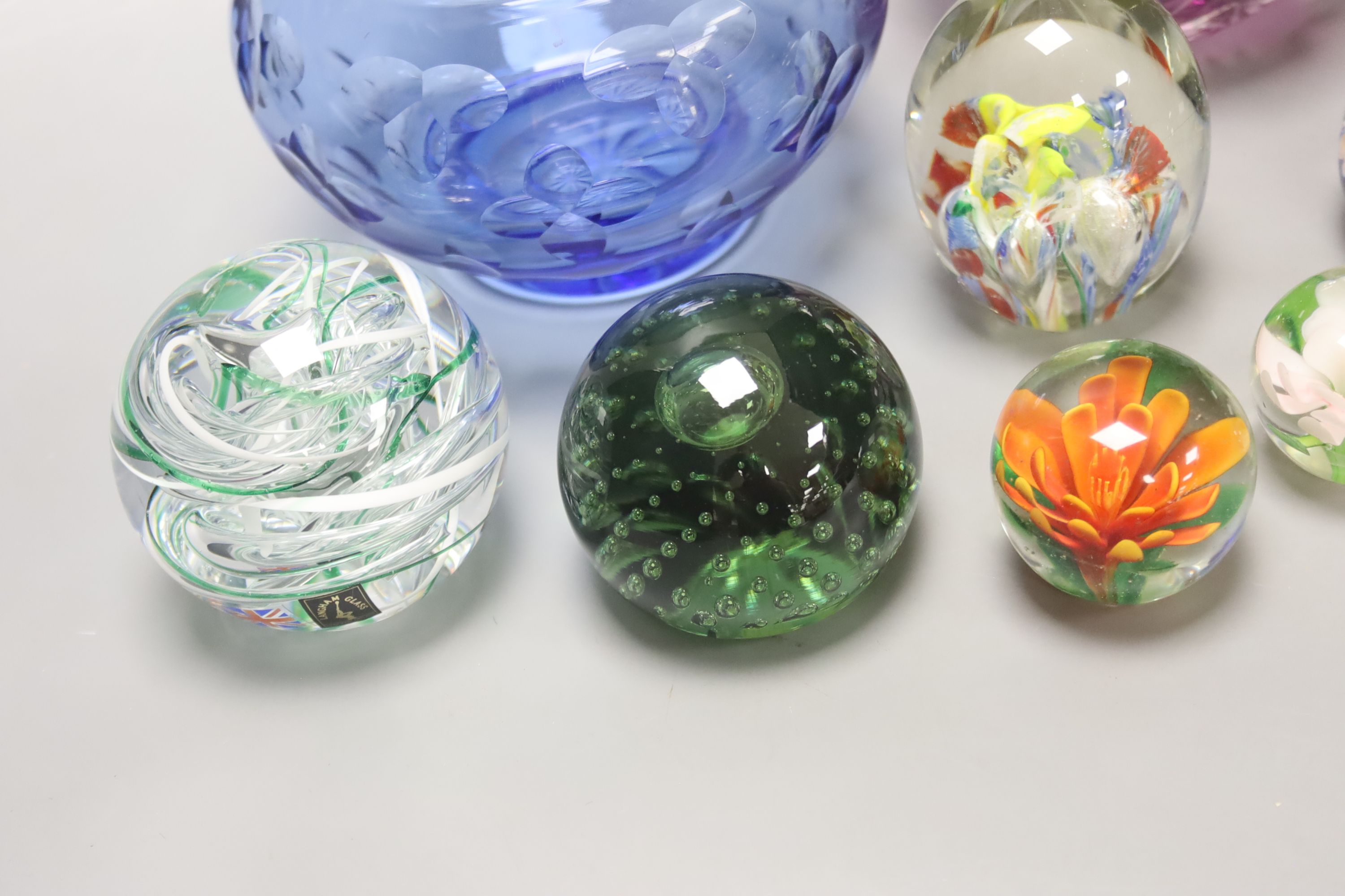 A group of coloured glassware including paperweights